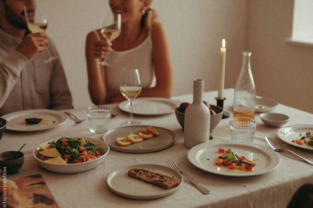 Vrienden aan tafel met witte wijn en gedekte borden