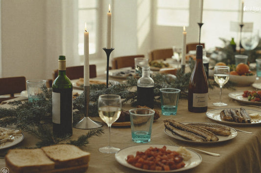 Kersttafel met kaarsen, wijn en gedekte borden